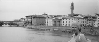 Black and white photograph of grand buildings along a river bank